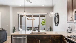 Una cucina moderna con isola centrale, elettrodomestici in acciaio inossidabile e illuminazione a sospensione.