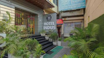 Ein Hotel Eingang mit einem Schild für 'HOTEL INDUS' und einer Treppe, die zum Eingang führt.