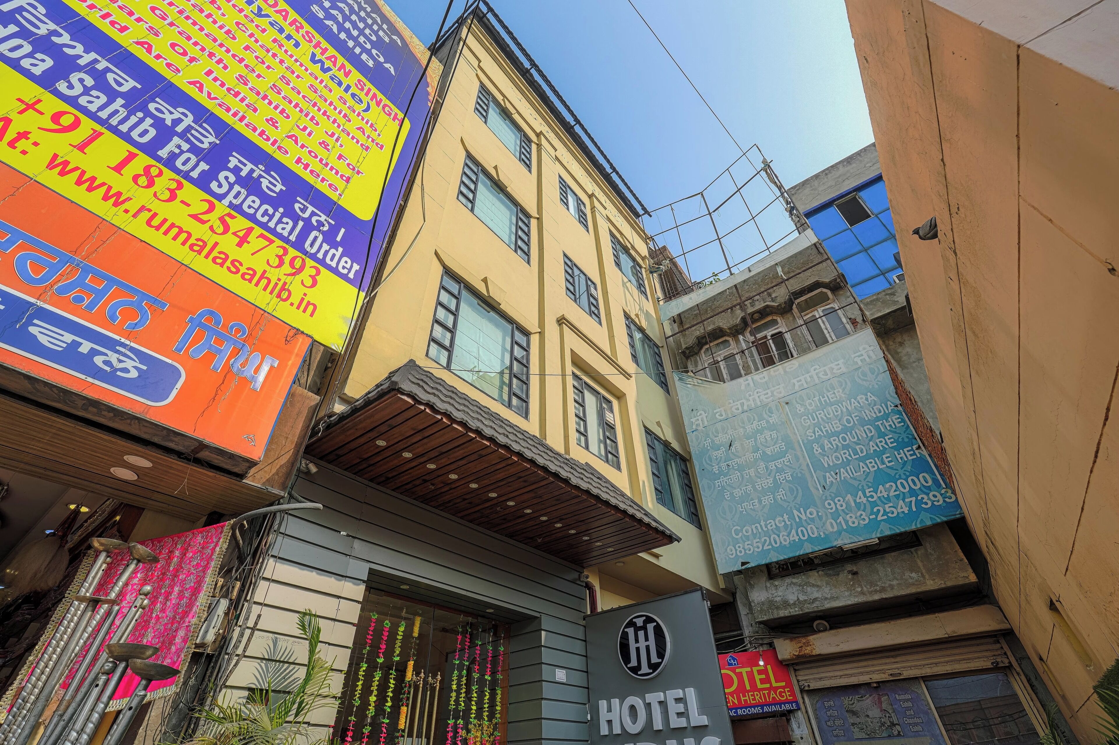 A multi-story building with a sign for a hotel and various colorful advertisements.