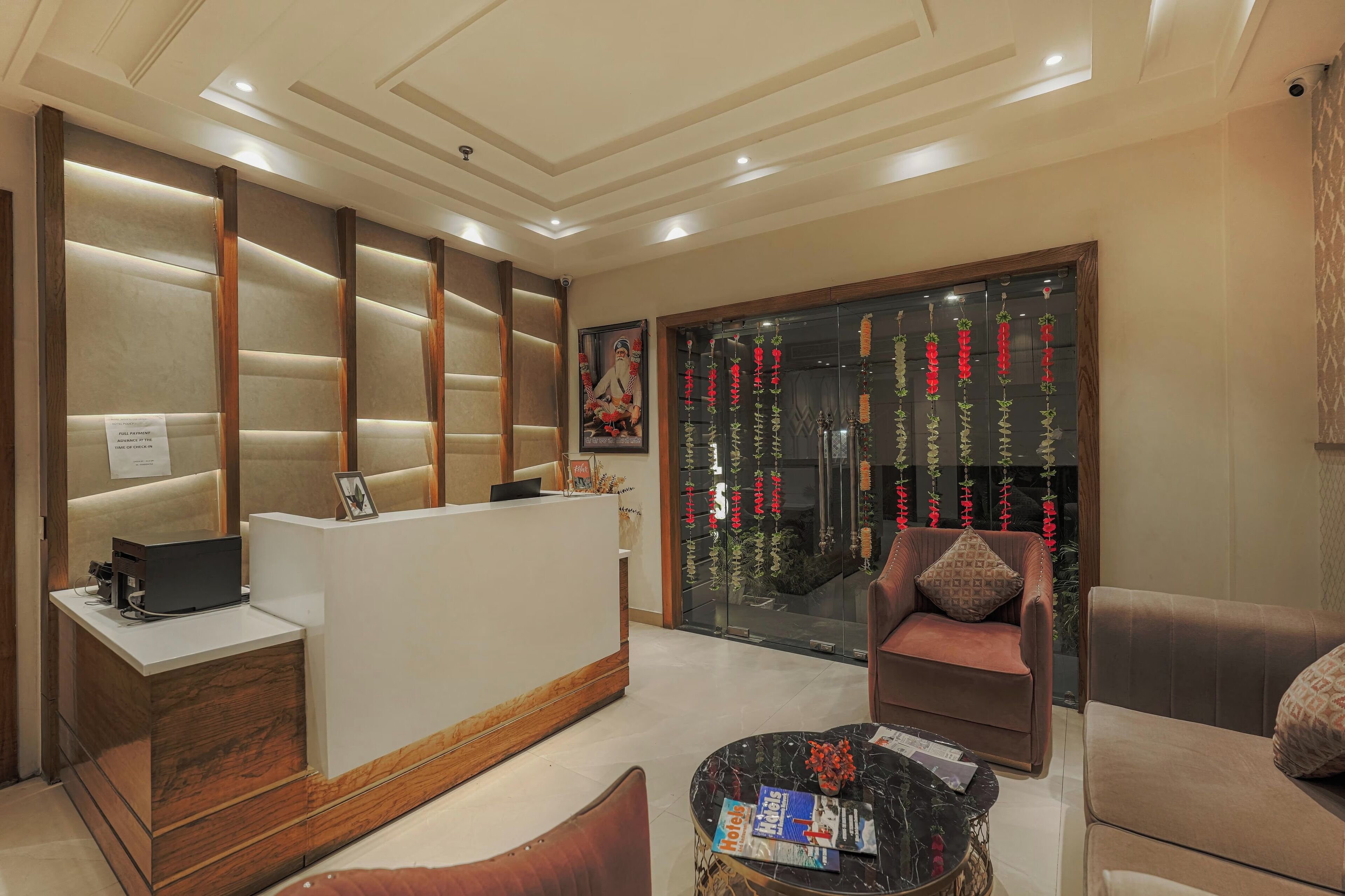 A hotel reception area with a modern design, featuring a reception desk, seating area, and decorative elements.
