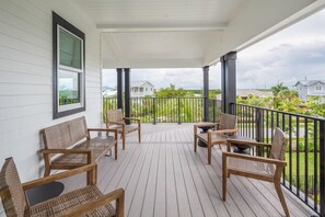 Eine überdachte Veranda mit Holzmöbeln und Blick auf die Nachbarschaft.