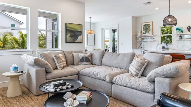 Una sala moderna con un sofá modular, una mesa de centro y vistas al exterior.