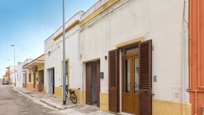 Eine Reihe von Gebäuden mit einheitlicher Architektur, mit Häusern, die Fensterläden besitzen, und einem Fahrrad, das vor der Tür steht.