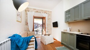 A compact living space with a kitchenette, a dining area, and a view through an open door. - Villa Danica ZadarVillas (Sukošan)