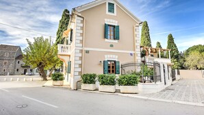 A two-story building with a beige facade, green shutters, and a balcony. - Villa Danica ZadarVillas (Sukošan)