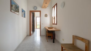 A hallway with a wooden bench, a table with a bowl, and framed pictures on the wall. - 3606 Dimora Incantevole by Barbarhouse (Lecce)