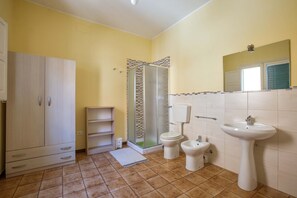A bathroom with a shower, toilet, bidet, sink, cabinet, and a small shelf. - 3614 Dimora La Torre by Barbarhouse (Leverano)