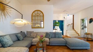 Ein Wohnzimmer mit einer Eckcouch, einem Couchtisch und einer Treppe zu einer weiteren Ebene.