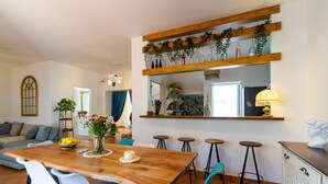 Ein Essbereich mit Holztisch, blauen Stühlen und einem Blumenstrauß.