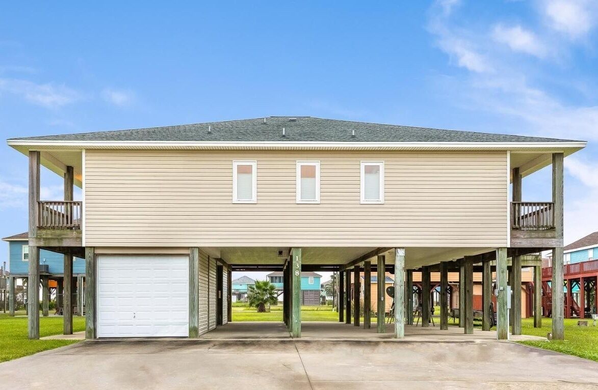 A two-story house with a covered garage and a balcony on the upper floor.