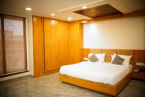 A modern bedroom with a wooden bed frame, a large wardrobe, and a ceiling with recessed lighting. - Signum Cityscape landmark Dahej (Vagra)