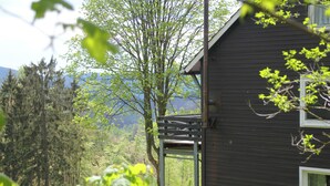 Una cabana de fusta amb un balcó que dona a una zona boscosa.
