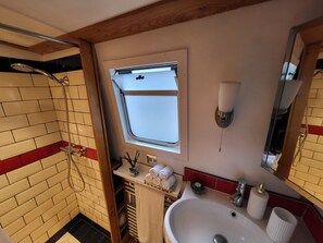 Een douche, handdoeken, zeep, toiletpapier