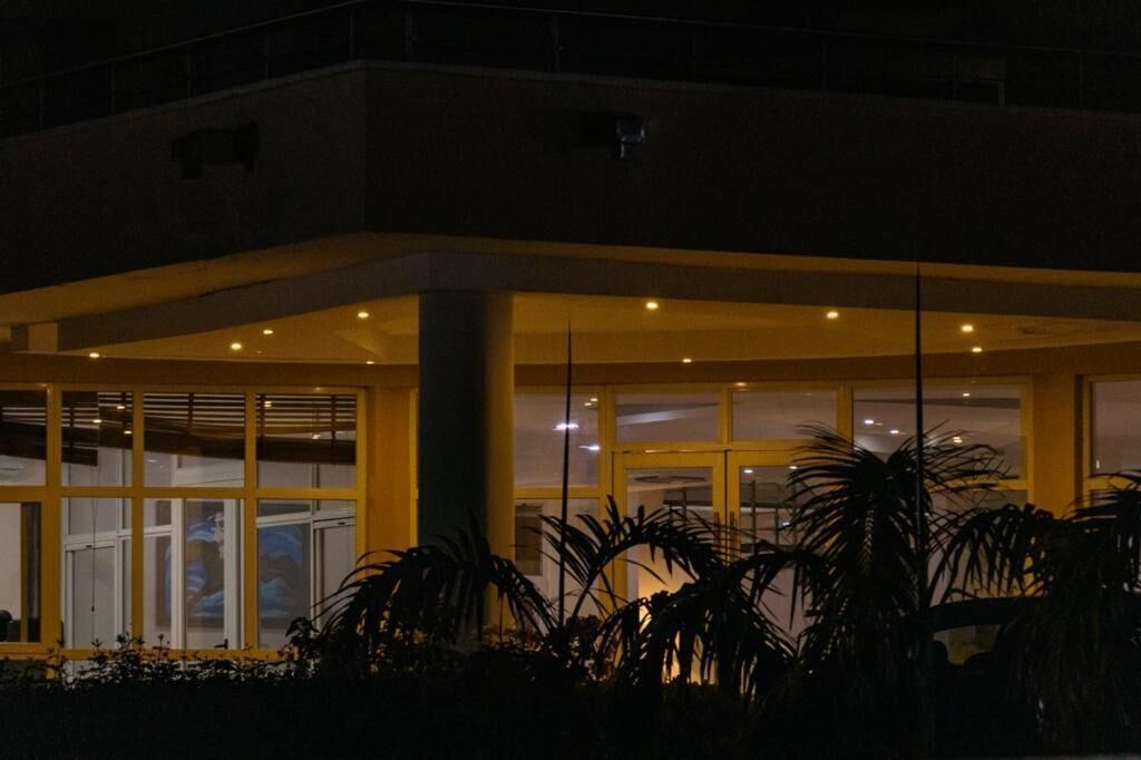 A building with a covered entrance, large windows, and a central pillar.