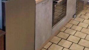 Une cuisine moderne équipée d’un four encastré, d’un four à micro-ondes, d’un réfrigérateur en acier inoxydable et d’un évier.