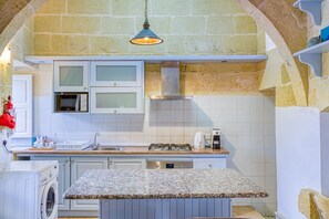 A kitchen with white cabinets, a built-in microwave, a gas stove, and a granite countertop.