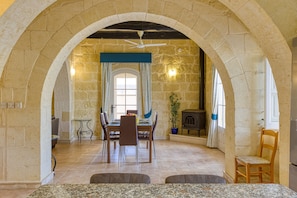 Un coin repas avec un mur en pierre, une table en bois et des chaises.