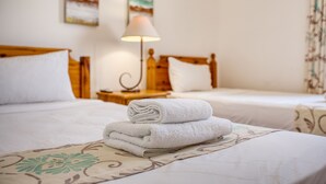 A hotel room with two beds, a lamp, and artwork on the wall. - Hgieri - Ghasri Holiday Home (L-Għasri)