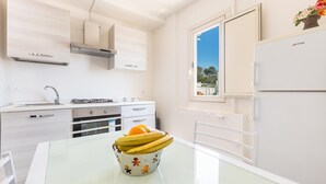 Eine moderne Küche mit weißen Schränken, einem Gasherd und einer Bananenschale auf dem Tisch.