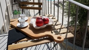 Uma varanda com mesa posta para o café da manhã, com vista para um vinhedo.