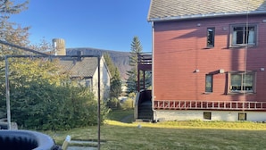 Un bâtiment rouge doté d’un porche abrité, d’un petit jardin et d’un jacuzzi.