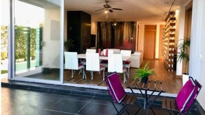 Un intérieur moderne comprenant un coin repas, un ventilateur de plafond et un escalier menant à un niveau supérieur.