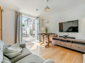 A modern living room with a sofa, a pool table, a television, and a sliding glass door leading to an outdoor area. - 4 bedroom accommodation in St Just-in-Roseland, near St Mawes (St Just-in-Roseland, near St Mawes)