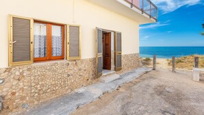 A coastal building with a stone facade, wooden shutters, and a balcony overlooking the sea. - 3533 Il Giglio Azzurro by Barbarhouse (Salve)