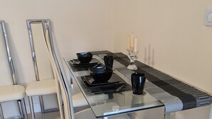 Een moderne eettafel met zwarte kommen, een zwarte mok en een kandelaar.