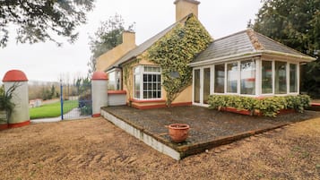 Stunning house with a unique architectural style, featuring a conservatory and beautifully maintained garden.