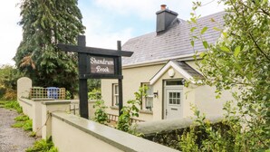 A sign reading "Shandrum Brook" in front of a house with a white exterior and grey roof. - SHANDRUM BROOK, pet friendly, country holiday cottage in Charleville (Charleville)