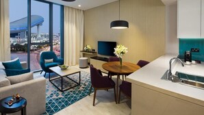 Una habitación de hotel moderna con un ventanal grande, una zona de comedor y una cocina.