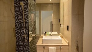 A modern bathroom with a large mirror, a sink, and a shower. - Standard Room Near Jadaf Metro (Dubai)