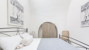 Ein Schlafzimmer mit einem Bett, einem Kleiderschrank und zwei an der Wand befestigten Kunstwerken.