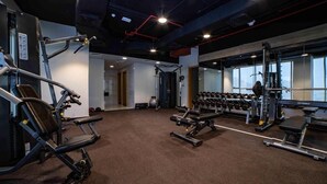 A gym with various exercise equipment, including treadmills, weight machines, and dumbbells. - Studio Apartment Near Century Mall By E R (الفجيرة)