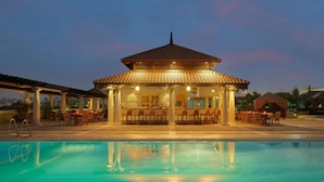Una piscina con un'area relax coperta e un bar.