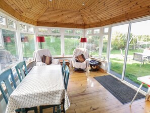 Enjoy a warm and inviting space with a dining table, comfortable seating area, and garden views.