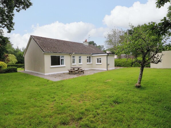 A single-story house with a tiled roof, a front porch, and a small garden area. - ROWANTREE, family friendly, with open fire in Beaufort, County Kerry (Beaufort, Killarney)