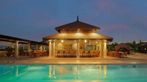A poolside area with a covered seating area, a bar, and a pool. - 1 Bedroom Apartment Near Gold Souk Metro BY E R (Dubai)