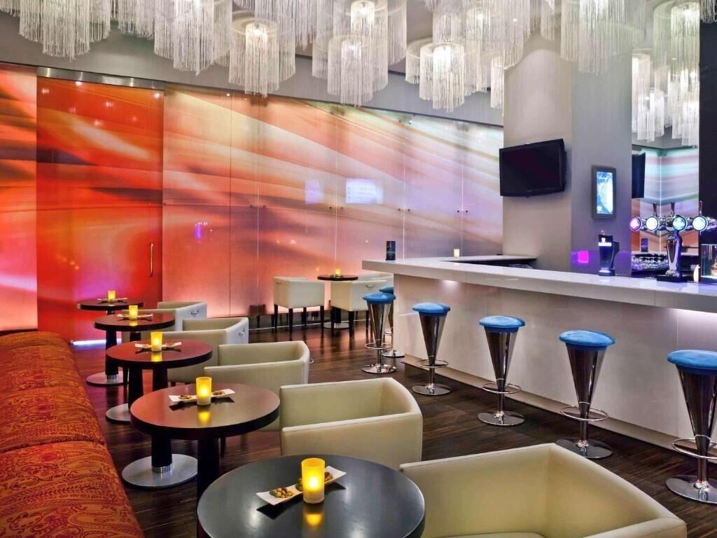 A modern lounge area with a bar, seating, and ambient lighting.
