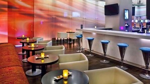Ein stilvoller Lounge-Bereich mit Bar, Sitzgelegenheiten und stimmungsvoller Beleuchtung.