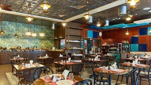 A restaurant with multiple dining tables and chairs, a bar area, and a decorative ceiling. - Deluxe Room Near Mashreq Metro Station By E R (Dubai)