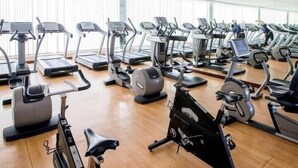 A gym with various exercise machines including treadmills, elliptical trainers, and stationary bikes. - Two Bedroom Suite Near Dic Metro (Dubai)