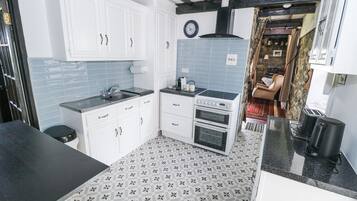 Een koelkast, kookgerei, borden en bestek