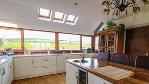 A modern kitchen with a large window, wooden countertop, and a view of the outdoors. - MILLERS LANE HOUSE, pet friendly in Muff, County Donegal (Muff)