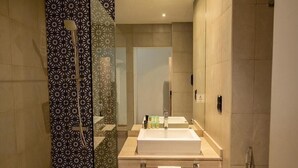 Een moderne badkamer met een grote spiegel, een wastafel en een douche.