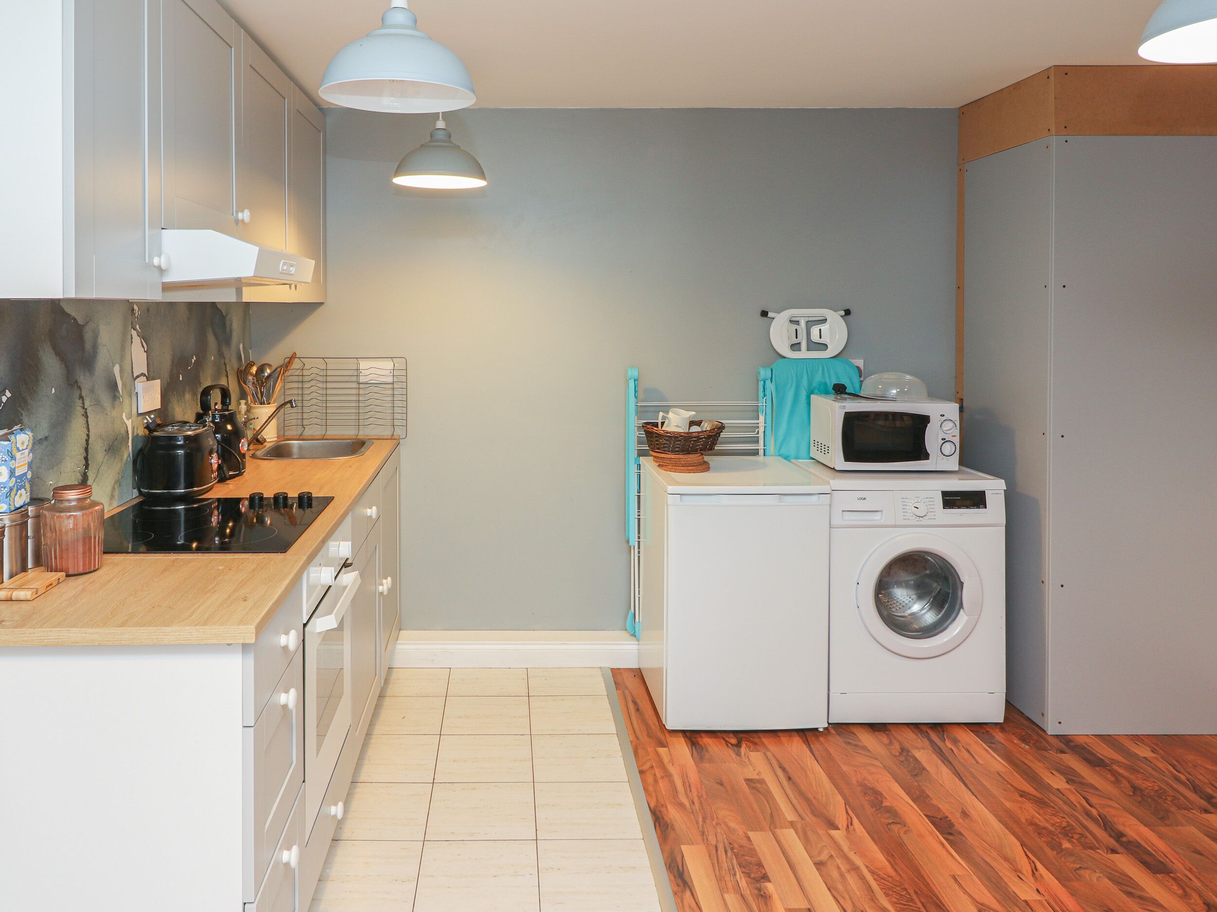 Een koelkast, een microgolfoven, een oven, kookgerei, borden en bestek