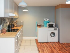 Een koelkast, een microgolfoven, een oven, kookgerei, borden en bestek