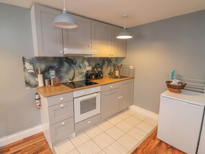 Een koelkast, een microgolfoven, een oven, kookgerei, borden en bestek