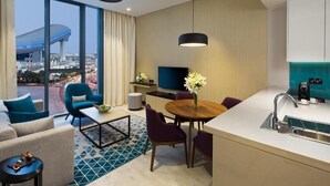 A modern hotel room with a city view, a dining area, and a kitchenette. - Two Bedroom Apartment Near Moe By E R (Dubai)